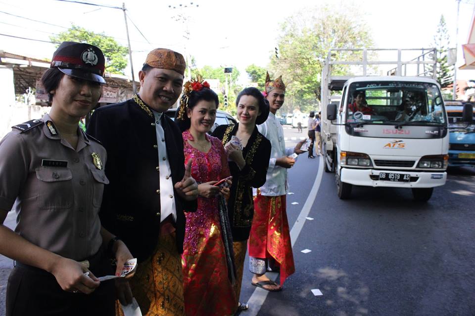 Berbusana Adat, Polantas Polda Sulut Bagikan Sticker dan Bunga